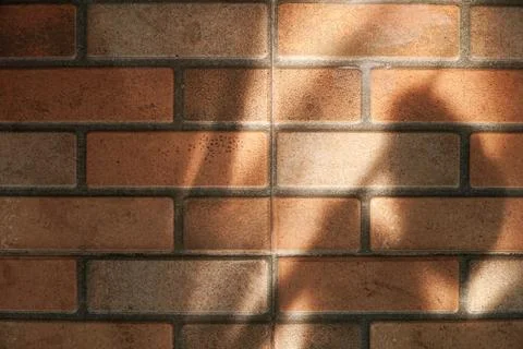 Rustic Red Brick Wall Texture with Natural Sunlight Shadows 스톡 사진