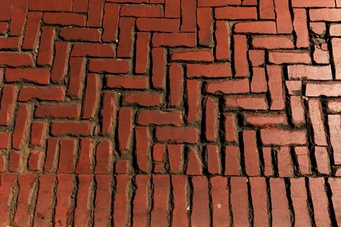Rustic red clay brick walkway texture, old herringbone pattern street pavement Stock Photos