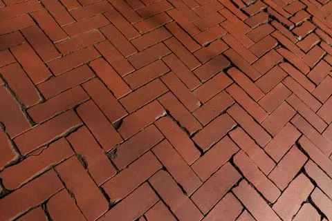 Rustic red clay brick walkway texture, old herringbone pattern street pavement Stock Photos