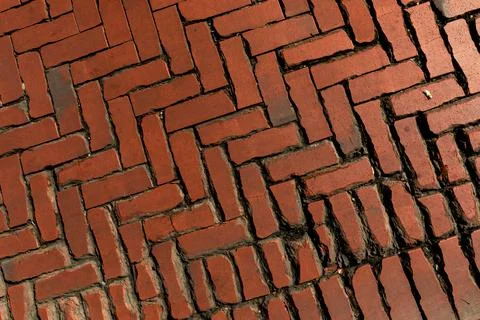 Rustic red clay brick walkway texture, old herringbone pattern street pavement Stock Photos
