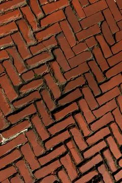 Rustic red clay brick walkway texture, old herringbone pattern street pavement Stock Photos