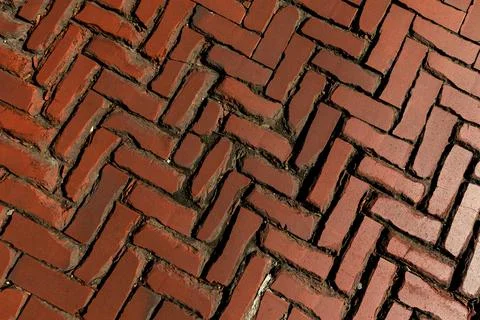 Rustic red clay brick walkway texture, old herringbone pattern street pavement Stock Photos