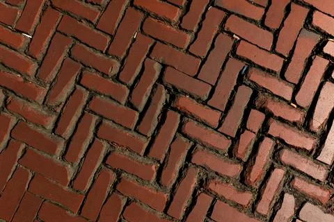 Rustic red clay brick walkway texture, old herringbone pattern street pavement Stock Photos