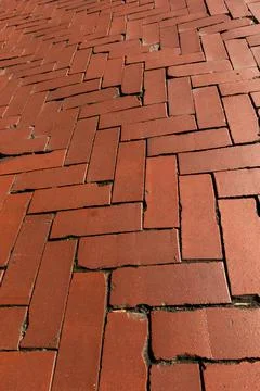 Rustic red clay brick walkway texture, old herringbone pattern street pavement Stock Photos
