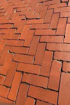 Rustic red clay brick walkway texture, old herringbone pattern street pavement Stock Photos