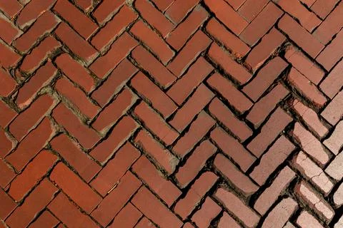 Rustic red clay brick walkway texture, old herringbone pattern street pavement Stock Photos