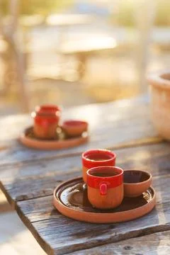Rustic red clay coffee cups placed on a trays on a wooden table Stock Photos