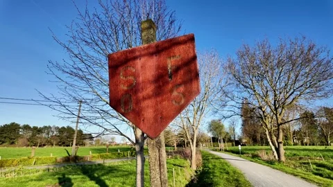 Rustic red diamond-shaped sign on a country dirt road. Vídeos de archivo 333208997