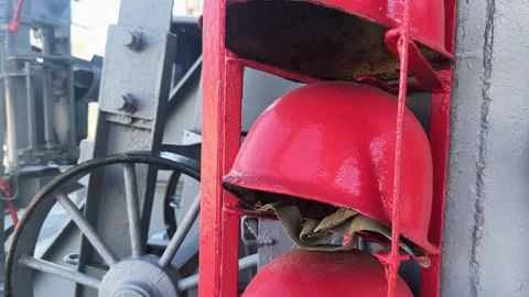 Rustic red firefighter helmets are neatly arranged against a gray industrial  Stock Footage 297438561