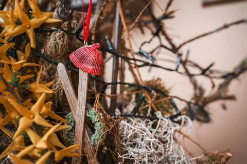 Rustic red knitted hat hanging against natural elements on blurred background Stock Photos