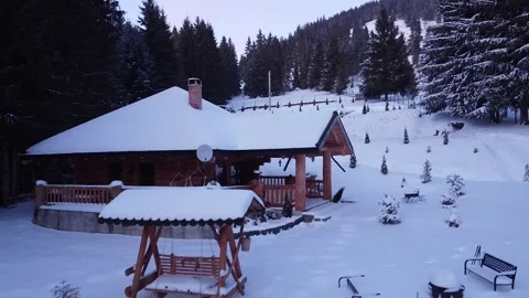 Rustic Refuge: Aerial Perspective of Snow-Clad Log House Stock Footage 262900813