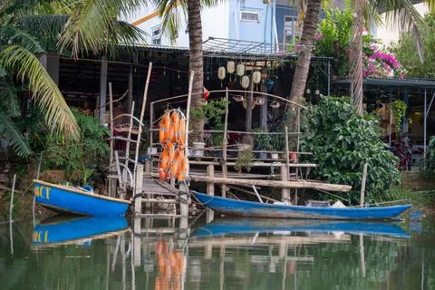 Rustic Riverside Dock with Traditional Blue Boats and Life Buoys Stock-Fotos