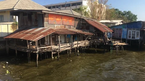 Rustic riverside shack with wavy water in Thailand - In 4k Stock Footage 104932771