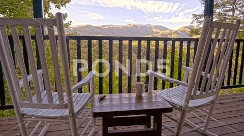 Rustic rocking chairs overlook mountain peaks
