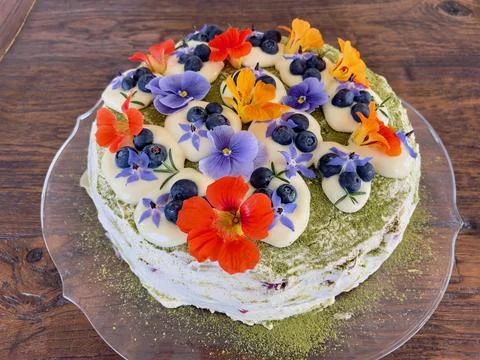 Rustic round sweet cake decorated with matcha green tea powder, orange, yellow a Stock Photos