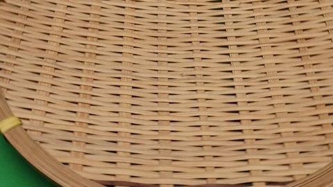 Rustic round woven bamboo tray closeup pan move rotate Stock Footage 261949383