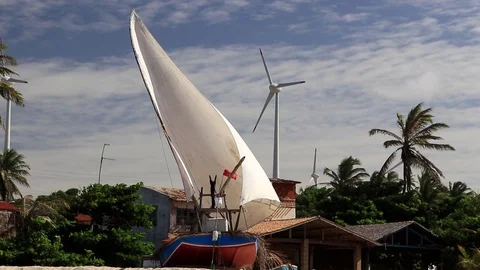 Rustic sailing boat in the sand, in the background wind power production the sta Stock Footage 111232968