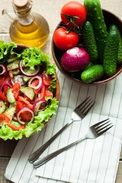 Rustic salad of fresh tomatoes, cucumbers, red onions and lettuce, dressed .. Stock Photos