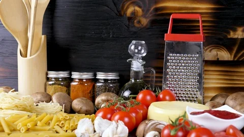 Rustic scene with raw uncooked pasta next to other fresh ingredients for dinner Stock Footage 94984066
