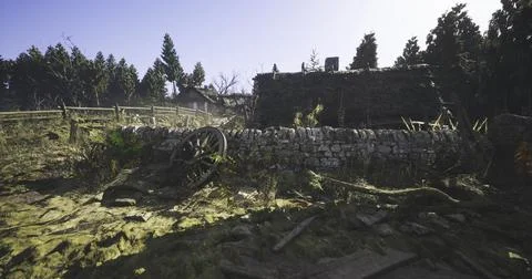 Rustic scene with a stone wall and wood structures in bright sunlight Illustrazione stock