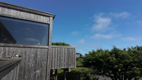 Rustic seaside building with large windows and fog flying Stock Footage 285789145