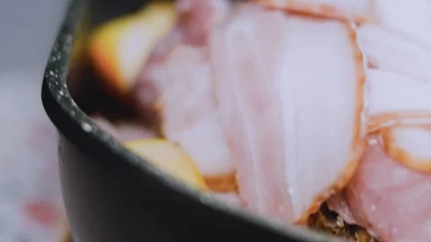 Rustic seasonal cooking: placing bacon wrapped pork in a roasting pan Stock Footage 342184871