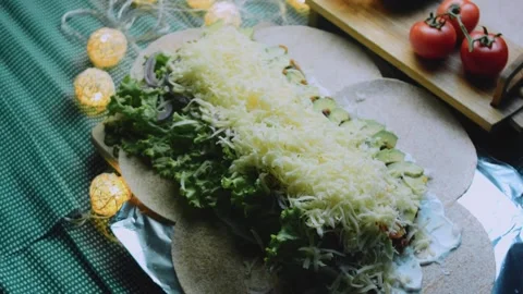Rustic serving view: wrapping a large burrito in foil Stock Footage 342168054