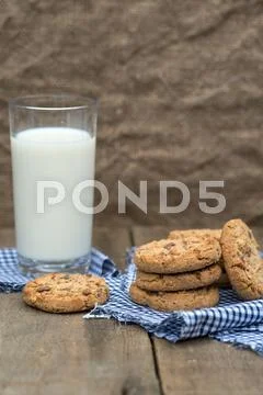 Rustic setting with chocolate chip cookies and glass of milk Stock Photos