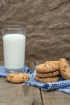Rustic setting with chocolate chip cookies and glass of milk Stock Photos