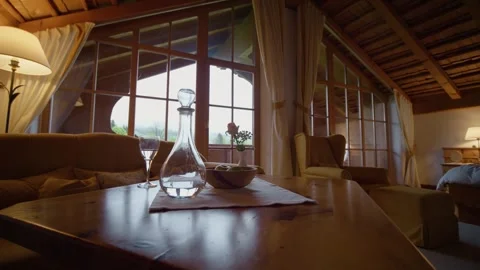 Rustic setting of wooden table with couch and missive armchair at rural chalet. Stock Footage 300014341