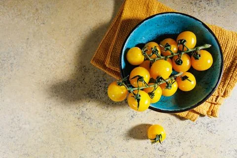 Rustic setting with yellow cherry tomatoes and kitchen towel Stock Photos