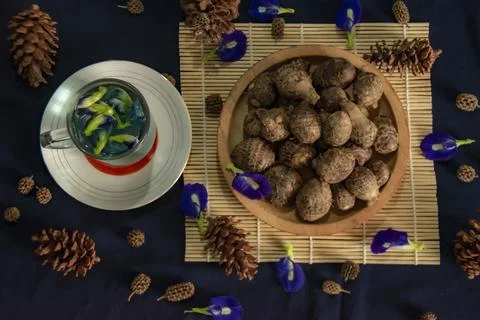 Rustic setup in flat lay of tropical eddoes and vibrant blue clitoria ternatea Stock Photos