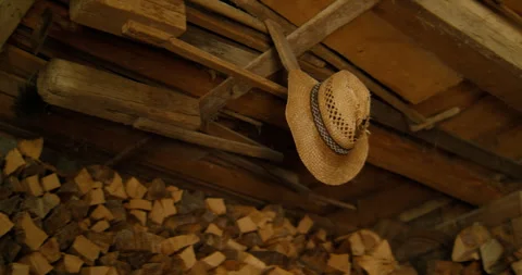 Rustic Shed Interior: Straw Hat Hanging Above Firewood Stack Stock Footage 334817682