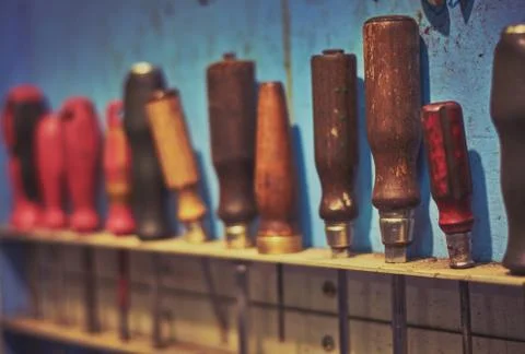 Rustic shelf with plenty hanging screwdrivers with differently colored handle Stock Photos