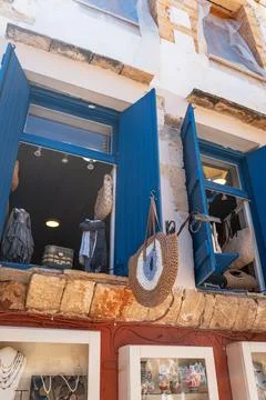 Rustic shop facade with blue shutters and an evil eye bag. Stock Photos