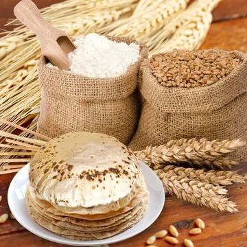 A rustic shot of a plate of chapati surrounded by ingredients 库存照片