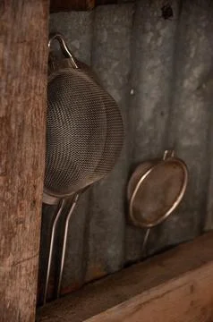 Rustic Sieves between Wood &amp;amp; Corrugated Metal in an Outdoor Kitchen Stock Photos