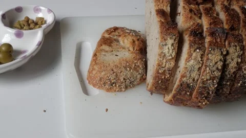 Rustic Sliced Bread and Olives on Cutting Board for Inviting Meal Stock Footage 334580062