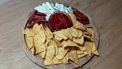 Rustic Snack Platter With Tortilla Chips and Dip on a Wooden Table Stock Footage 343369502