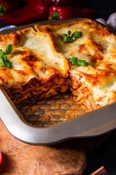Rustic spicy lasagne with basil on the tin. Stock Photos