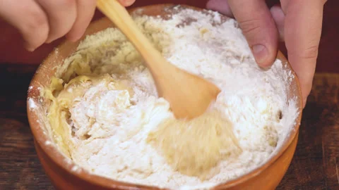 Rustic spoon whips egg yolk and flour in a bowl close up view Stock Footage 254167470