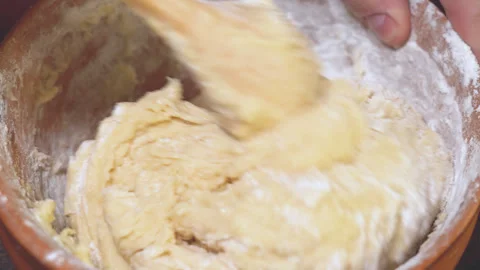 Rustic spoon whips egg yolk and flour in a bowl close up view Stock Footage 254167563