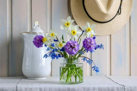 Rustic spring still life with fresh narcissus flowers, primrose bouquet and b 库存照片