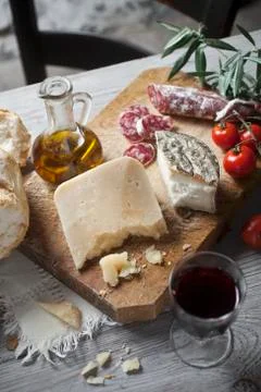 A rustic starter of sheep's cheese, bread, salami and red wine Stock Photos