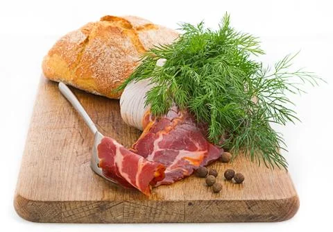 Rustic still life with bacon, bread, garlic and herbs Stock Photos