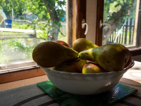 Rustic still life with a close-up of ripe apples and pears lying in a bowl by Stock Photos