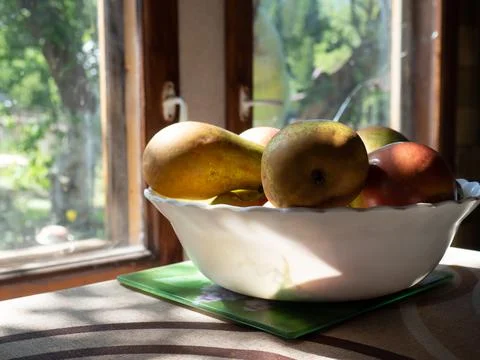 Rustic still life with a close-up of ripe apples and pears lying in a bowl by Stock Photos