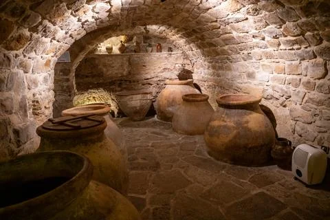 Rustic stone cellar with clay pots and jars Stock Photos