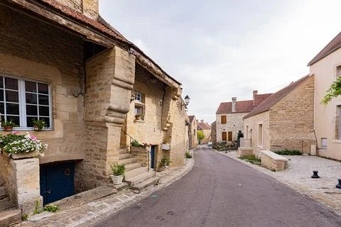 Rustic stone cottage with flower planters beside a village street, Yonne, M.. Stock Photos