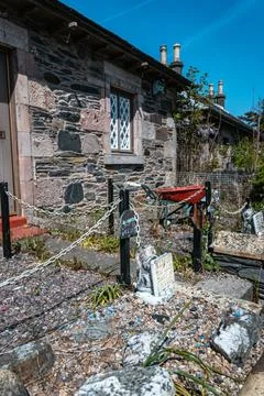 Rustic stone cottage garden with unique decorations in a Scottish village Stock Photos